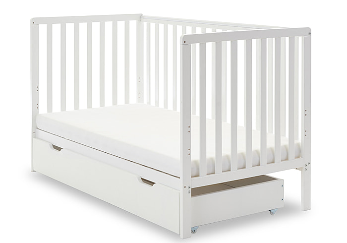 White wooden cot bed with open slat design and teething rails. Pull out drawer on castors under the cot.