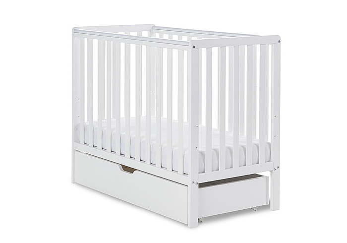 White wooden cot with open slat design and pull out under drawer. Teething rails included. Compact design.