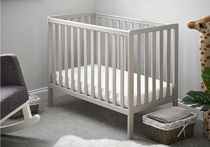 Light grey painted wooden cot with open slat design. Teething rails, 3 height positions