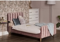 A luxurious pink velvet single bed frame with a deep padded headboard and footboard. Tapered gold legs.