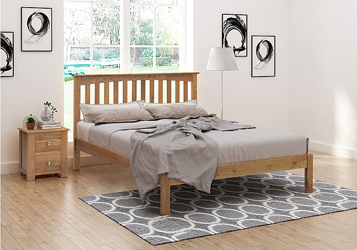 A stylish solid oak bed frame with a slatted headboard with plinth and low foot end.