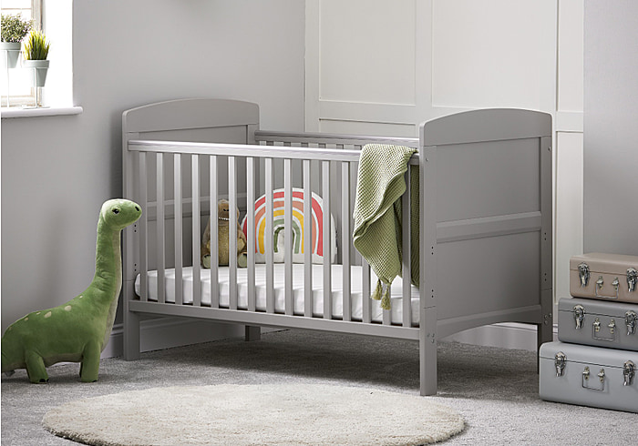 Warm grey cot bed with open slatted sides, solid end panels and 3 height positions. Teething rails included.
