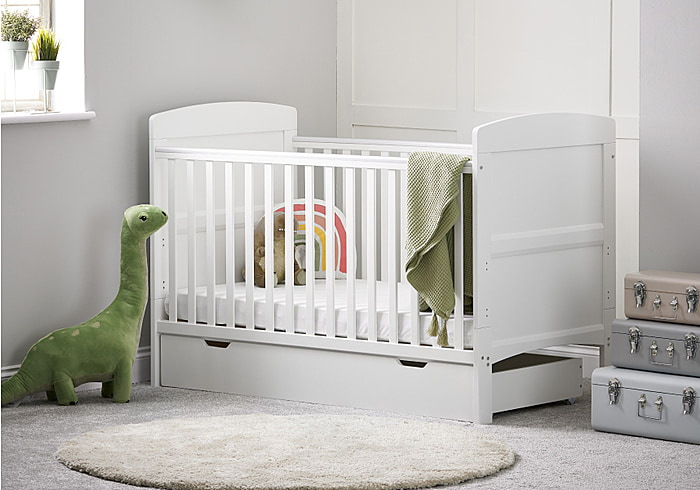 White cot bed with under drawer, open slatted sides, solid end panels and 3 height positions. Teething rails included.