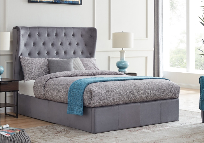 A luxurious grey upholstered ottoman bed frame with a buttoned, wing back headboard.
