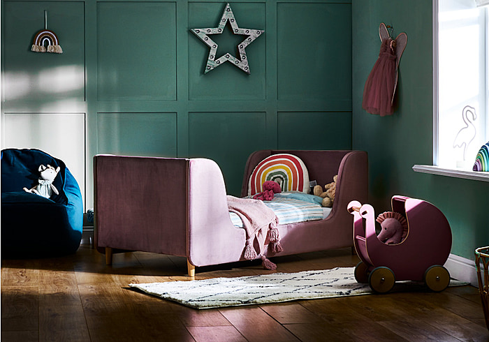 Luxury pink velvet toddler bed frame. Winged headboard and footboard and stylish wooden feet.