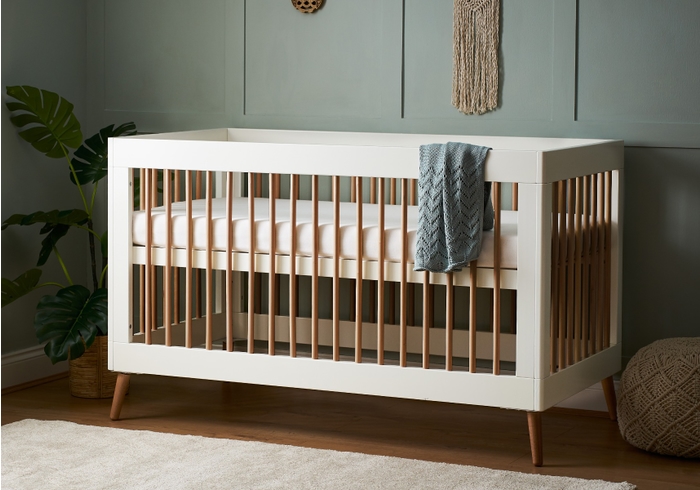 Modern Scandinavian design cot bed in a white and natural finish with a 3 base height positions.