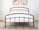 An elegant modern Victorian style metal bed frame. Curved head and foot boards with decorative details. Rustic shiny rose finish.