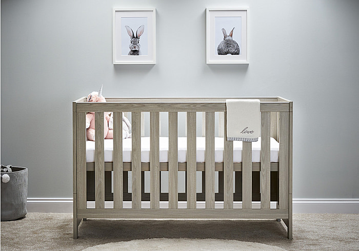 Grey wash contemporary cot bed with 3 mattress base heights and teething rails. Easily transforms to a toddler bed.