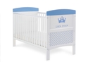 White cot bed with a royal themed design in blue, teething rails, 3 height adjustable base