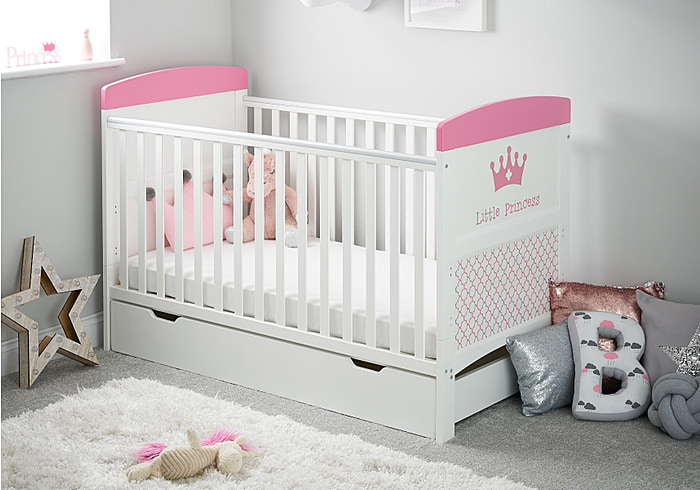White cot bed with under drawer. A royal themed design in pink, teething rails, 3 height adjustable base