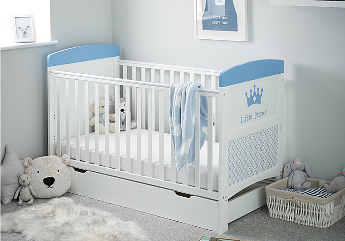 White cot bed with under drawer. A royal themed design in blue, teething rails, 3 height adjustable base