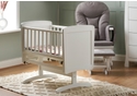 White wooden gliding baby crib with open slatted sides and solid end panels.