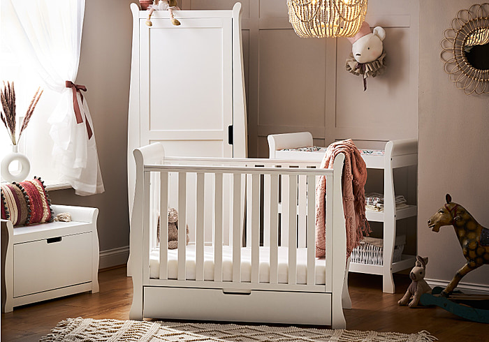 Elegant sleigh design white 3 piece nursery set. Cot bed with drawer, open changing unit and wardrobe.