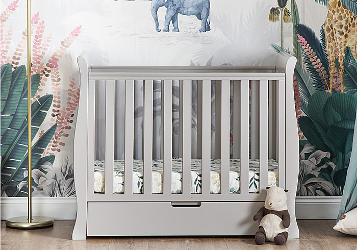 Warm grey, elegant sleigh style space saver cot with under drawer. 3 base heights, teething rails and open slatted sides.
