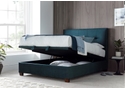 Luxurious deep blue velvet ottoman bed frame with modern dark wooden feet.