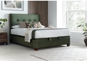 Luxurious moss green velvet ottoman bed frame with modern dark wooden feet.