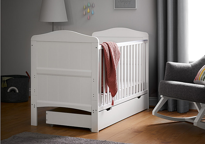 Beautiful coastal themed white wooden cot bed with under drawer. Grooved end panels with gentle curves. Includes teething rails.